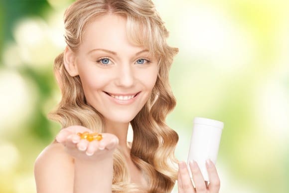 Smiling Woman Holding Omega-3 Capsules