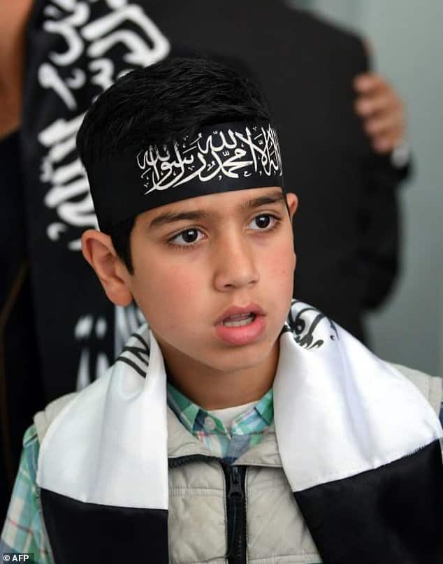 A Tunisian child wears a bandana reading "There is no god but Allah, and Mohammed is his prophet" during a meeting at Hizb ut-Tahrir's Tunisian headquarters on April 15, 2017