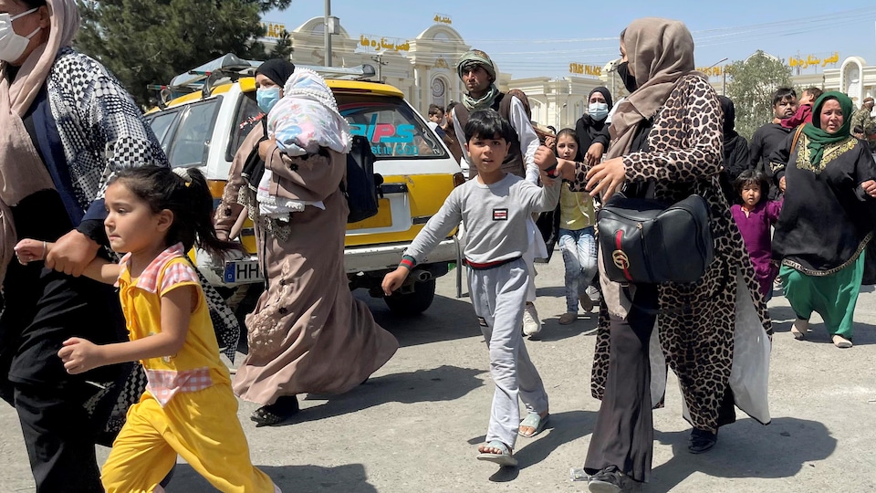 Women and children flee the arrival of the Taliban and try to access the Hamid Karzai airport in Kabul.